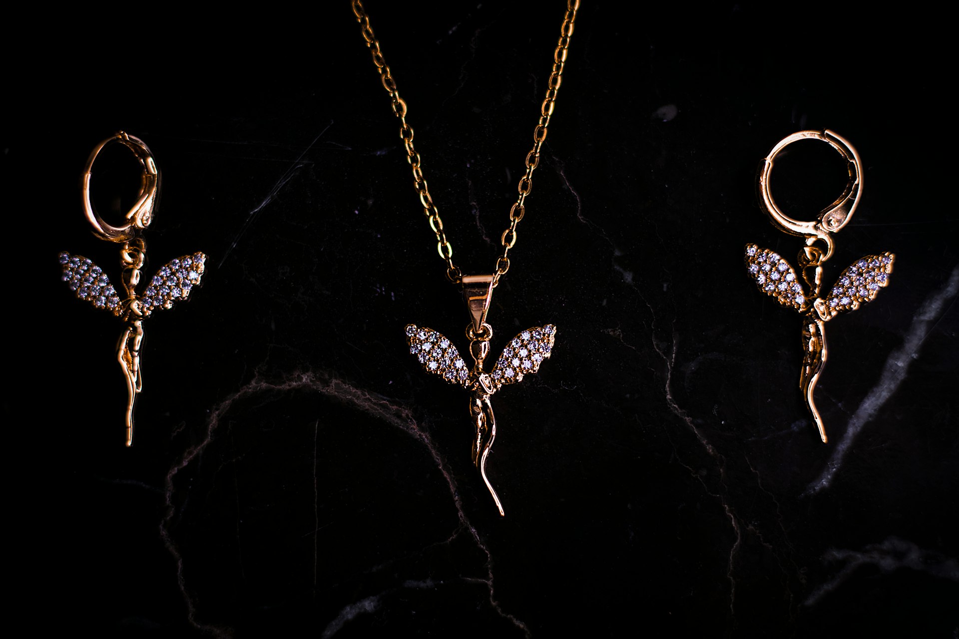 three pieces of jewelry on a black surface